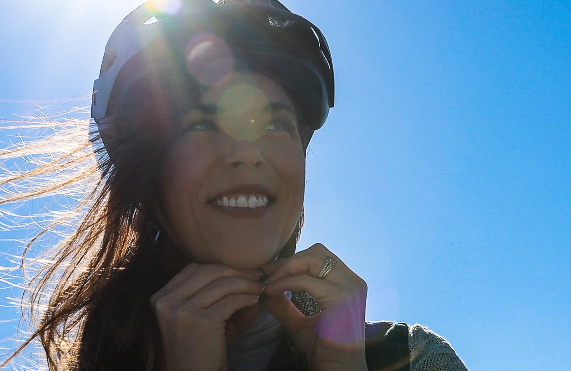 Woman straps on a helmet before getting on her ebike