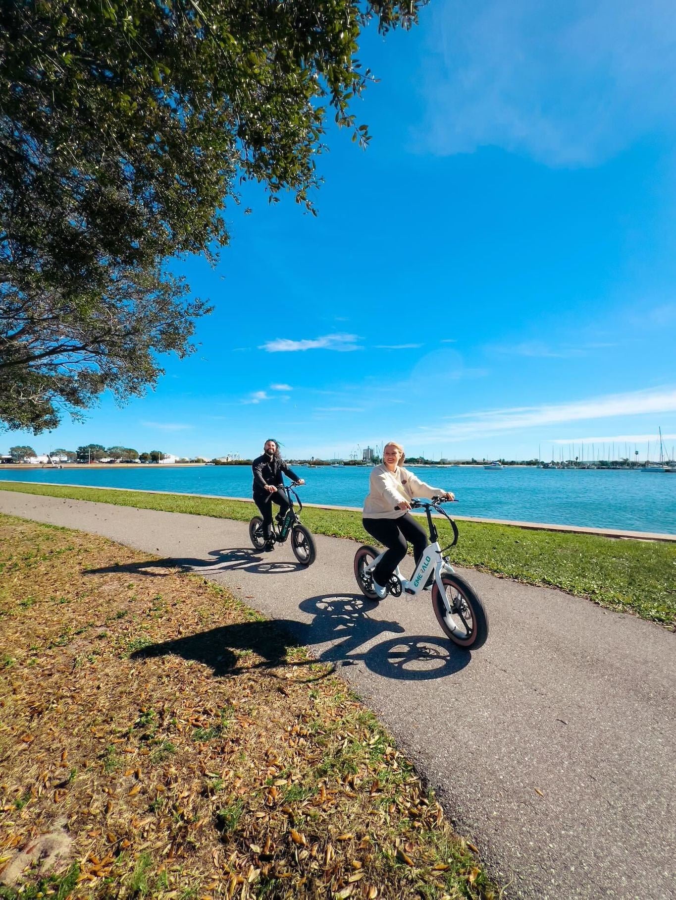 Couple riding a black and white emerald ebike on a trail.