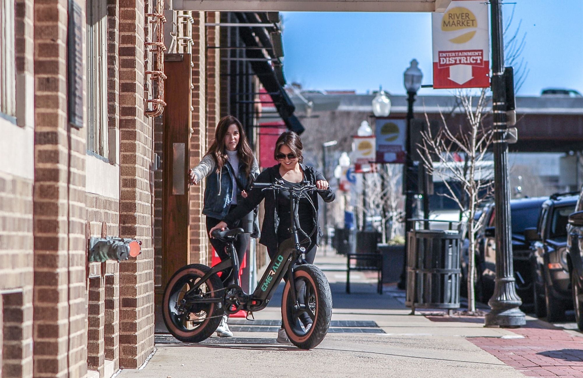 Two woman walking out of a building with an Emerald Ebike