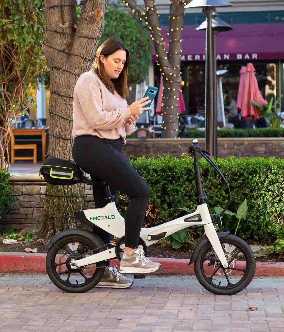 Woman stopping to check her phone on her ebike.