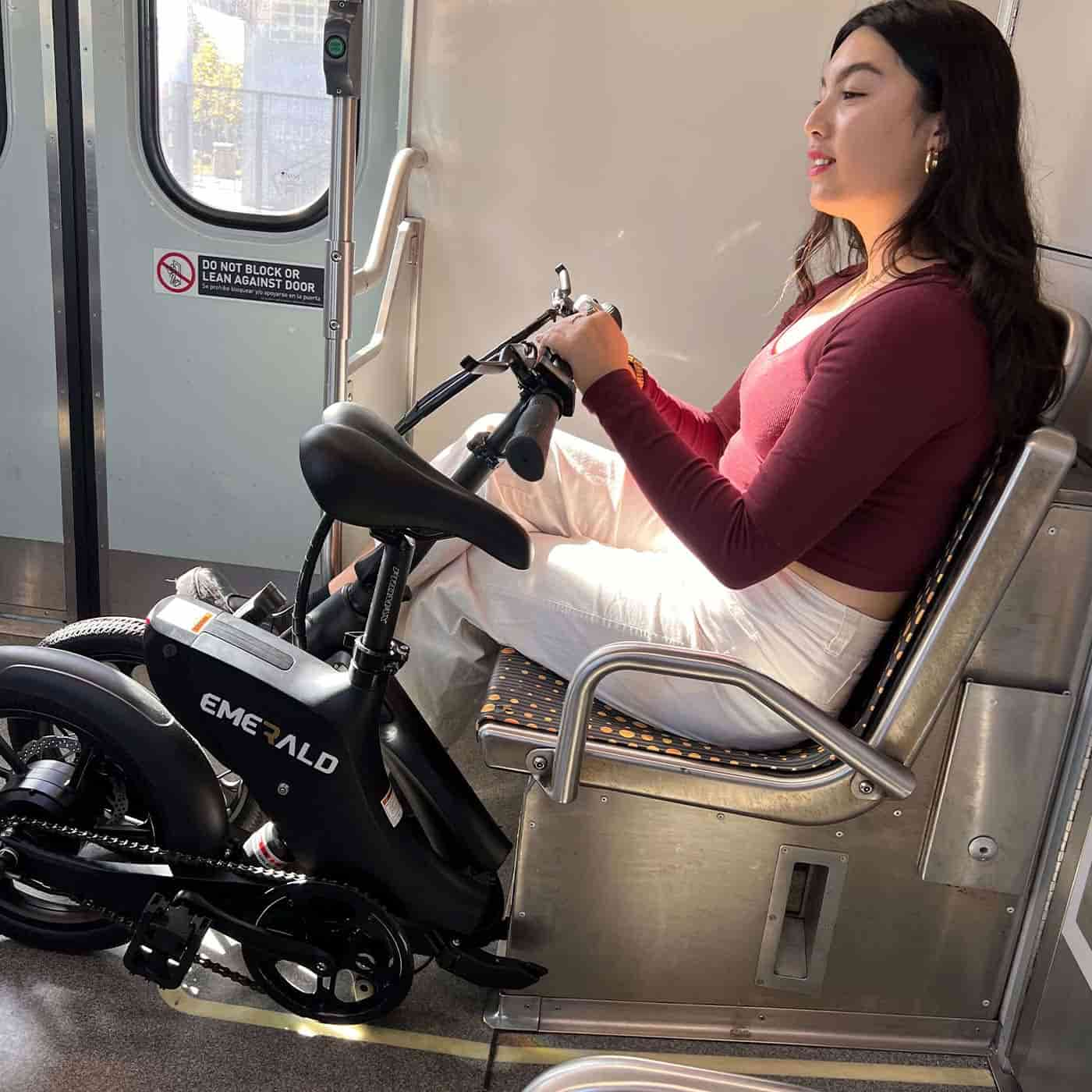 woman riding the train with her folded ebike.