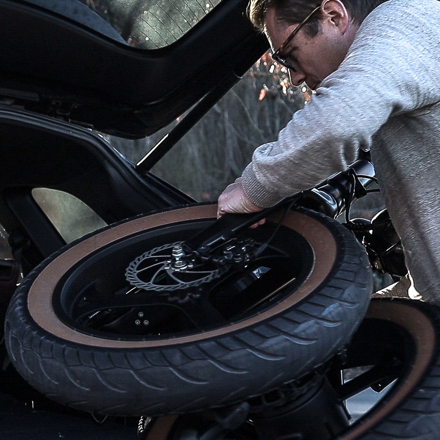Man fitting the folded Emerald ebike in the trunk of his car.